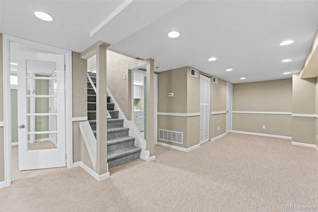 basement with washer / clothes dryer and light colored carpet