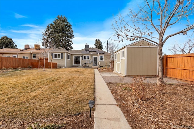 back of property featuring a yard and a shed