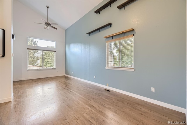 spare room with hardwood / wood-style flooring, high vaulted ceiling, and ceiling fan