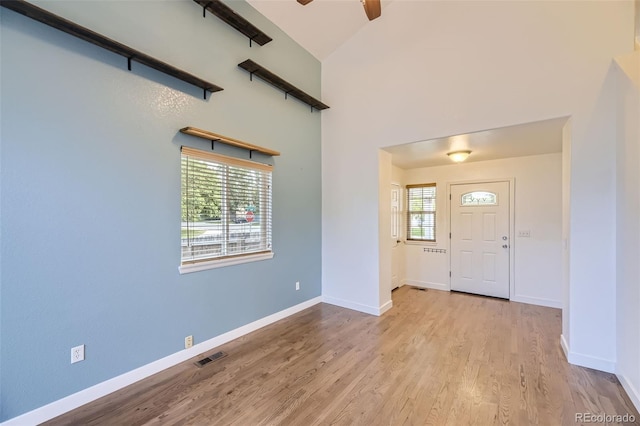 foyer entrance featuring lofted ceiling, ceiling fan, and light wood-type flooring