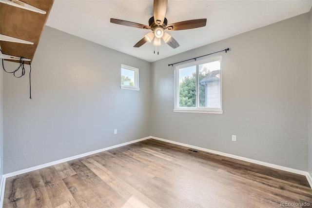 empty room with hardwood / wood-style floors and ceiling fan