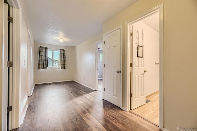 empty room with wood-type flooring and a textured ceiling