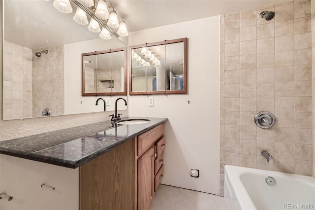 bathroom featuring tile patterned flooring, a textured ceiling, vanity, and tiled shower / bath