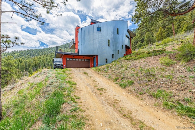 5896 Peregrine Trl, Golden, CO 80403 - view of side of home featuring dirt driveway, a forest view, and a chimney