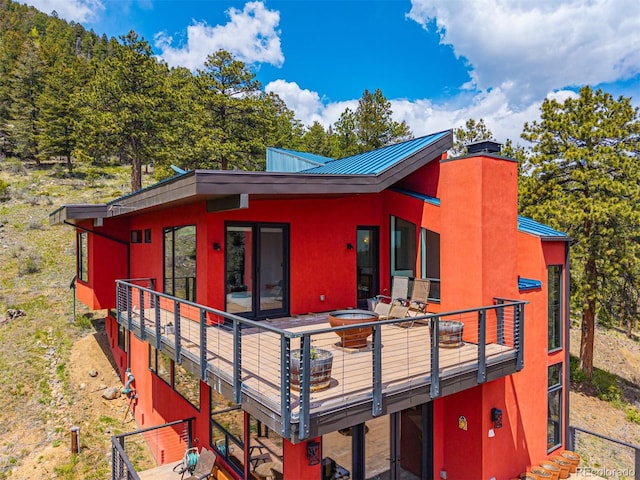 5896 Peregrine Trl, Golden, CO 80403 - view of front facade featuring metal roof, a standing seam roof, stucco siding, and an outdoor fire pit