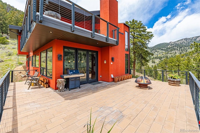 5896 Peregrine Trl, Golden, CO 80403 - view of patio with a fire pit, french doors, a balcony, and a mountain view