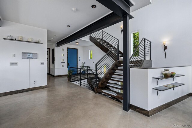 5896 Peregrine Trl, Golden, CO 80403 - stairs with finished concrete floors, baseboards, healthy amount of natural light, and recessed lighting