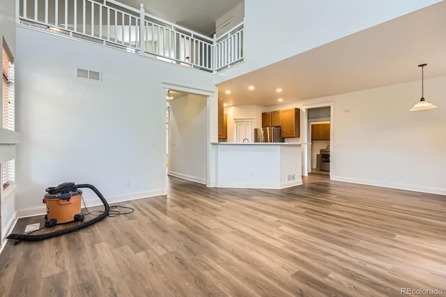 19259 E Caspian Pl, Aurora, CO 80013 - unfurnished living room with a high ceiling and light wood finished floors