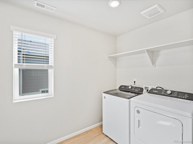 washroom with washer and dryer and light hardwood / wood-style floors