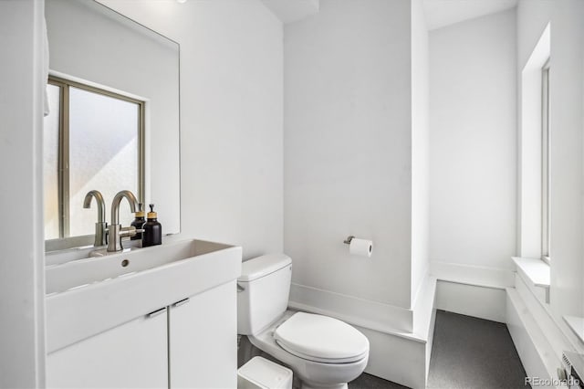 bathroom with toilet, vanity, and plenty of natural light