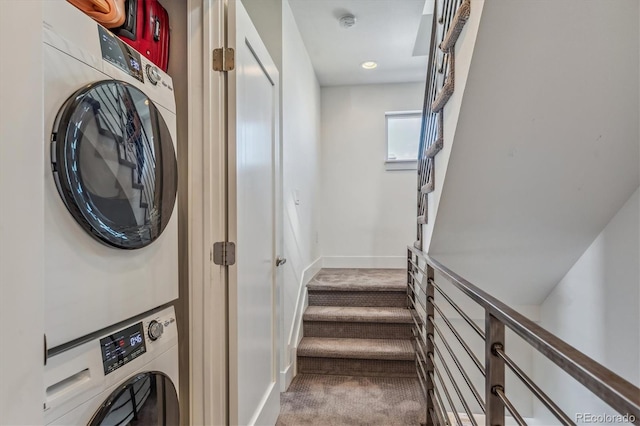 laundry room with stacked washing maching and dryer and carpet