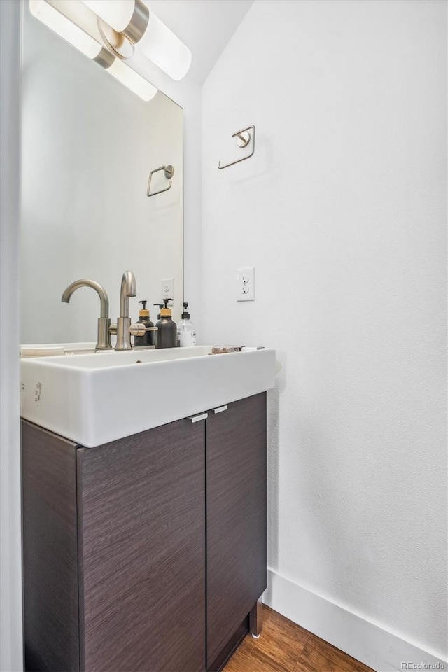 bathroom featuring vanity, baseboards, and wood finished floors