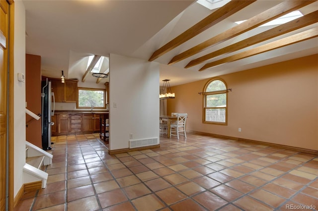 3722 Monterey Pl, Boulder, CO 80301 - kitchen with brown cabinetry, light tile patterned floors, freestanding refrigerator, a chandelier, and beam ceiling