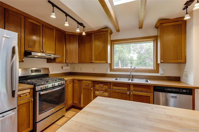 3722 Monterey Pl, Boulder, CO 80301 - kitchen with appliances with stainless steel finishes, under cabinet range hood, brown cabinets, and beam ceiling
