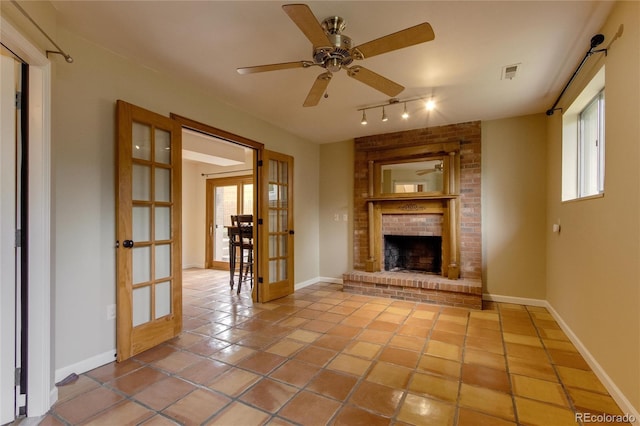 3722 Monterey Pl, Boulder, CO 80301 - unfurnished living room with french doors, rail lighting, tile patterned flooring, ceiling fan, and a brick fireplace