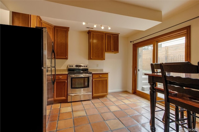 3722 Monterey Pl, Boulder, CO 80301 - kitchen featuring appliances with stainless steel finishes, brown cabinetry, light tile patterned flooring, and light countertops
