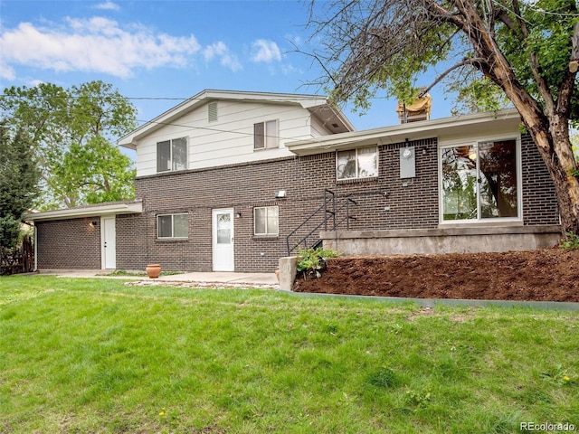 13561 W Alaska Pl, Lakewood, CO 80228 - view of front of house featuring brick siding, a patio area, and a front lawn