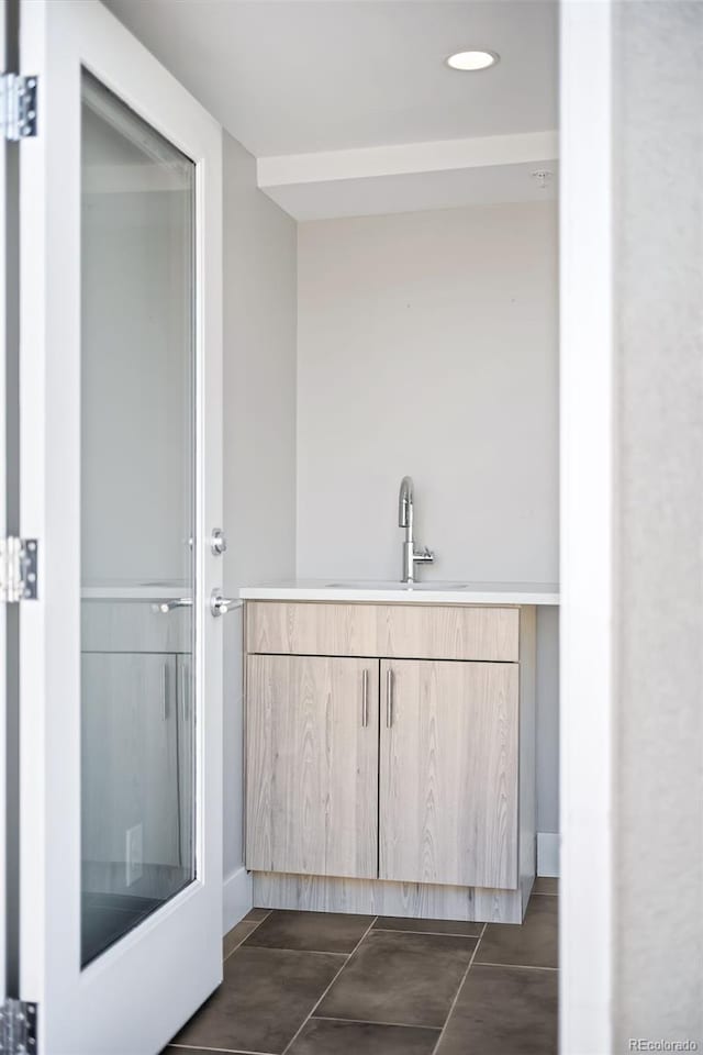 bathroom featuring tile patterned floors, baseboards, and vanity