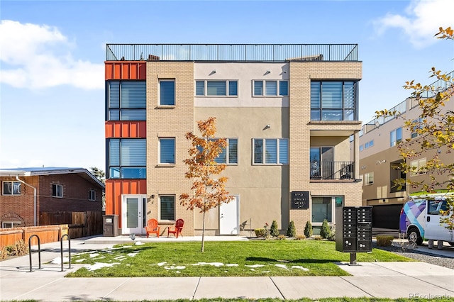 view of front facade featuring brick siding, stucco siding, a front lawn, and fence