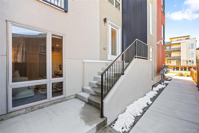 property entrance featuring stucco siding, a patio, and board and batten siding