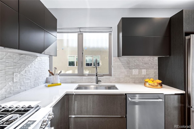 kitchen featuring tasteful backsplash, modern cabinets, light countertops, and a sink