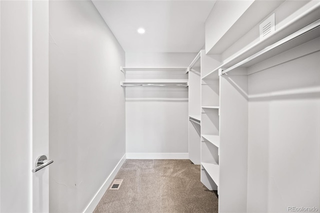 walk in closet with light colored carpet and visible vents