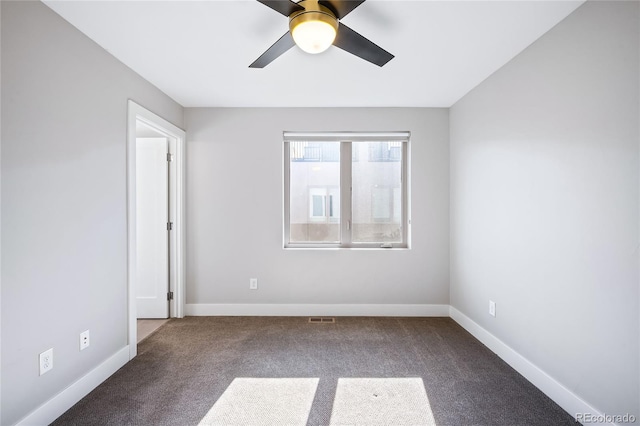 carpeted spare room with visible vents, a ceiling fan, and baseboards