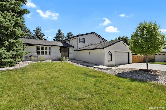 view of front of house featuring an attached garage, driveway, fence, and a front yard