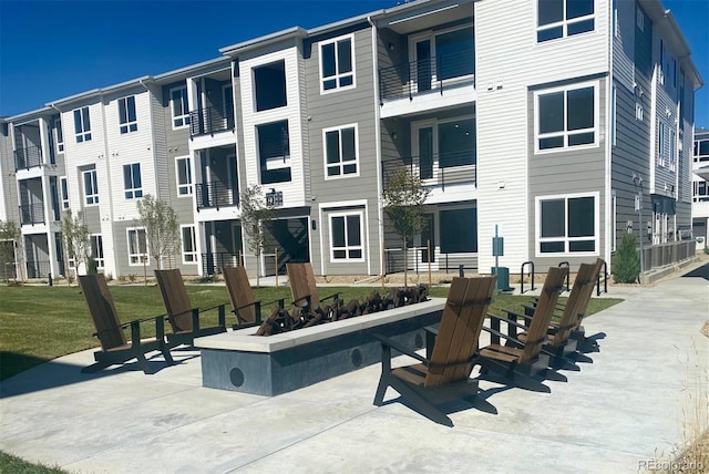 view of home's community featuring a fire pit and a lawn