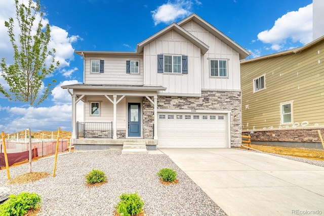 2142 S Irvington St, Aurora, CO 80018 - view of front facade featuring covered porch, board and batten siding, driveway, a garage, and stone siding