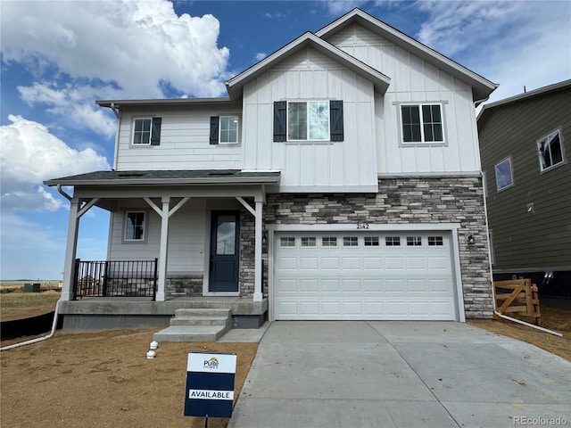 2142 S Irvington St, Aurora, CO 80018 - view of front of property featuring covered porch, concrete driveway, stone siding, an attached garage, and board and batten siding