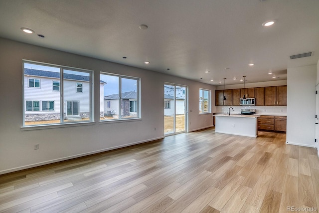 2142 S Irvington St, Aurora, CO 80018 - unfurnished living room with light wood-style flooring and recessed lighting