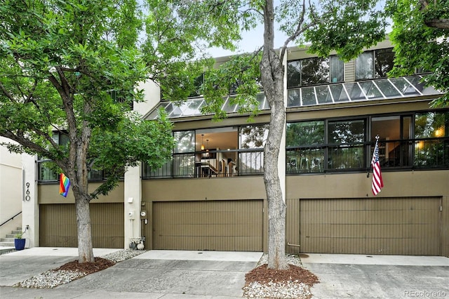 960 N Pennsylvania St Unit 6, Denver, CO 80203 - view of front of home with stucco siding, a garage, concrete driveway, and a balcony