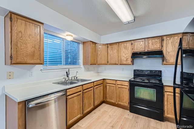 kitchen featuring electric range, fridge, under cabinet range hood, a sink, and dishwasher