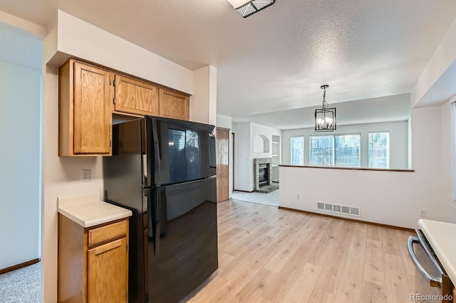 kitchen with visible vents, freestanding refrigerator, baseboards, light wood-type flooring, and light countertops