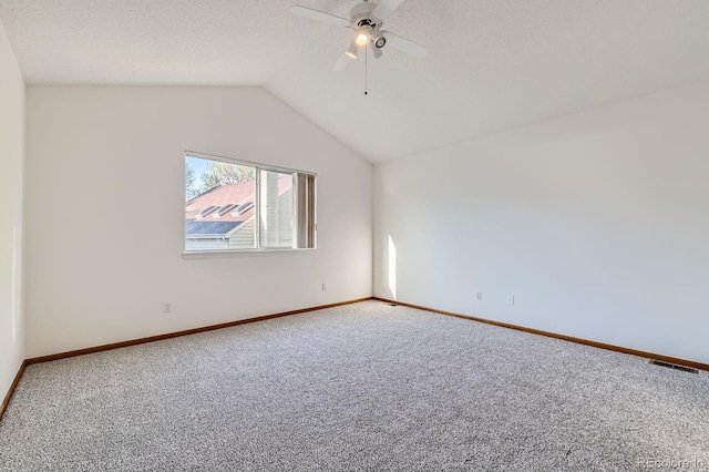 carpeted spare room with a ceiling fan, baseboards, visible vents, and vaulted ceiling
