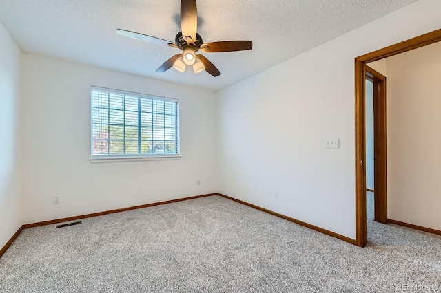 carpeted empty room with baseboards, a ceiling fan, and a textured ceiling