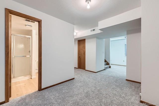 empty room featuring visible vents, carpet flooring, and baseboards