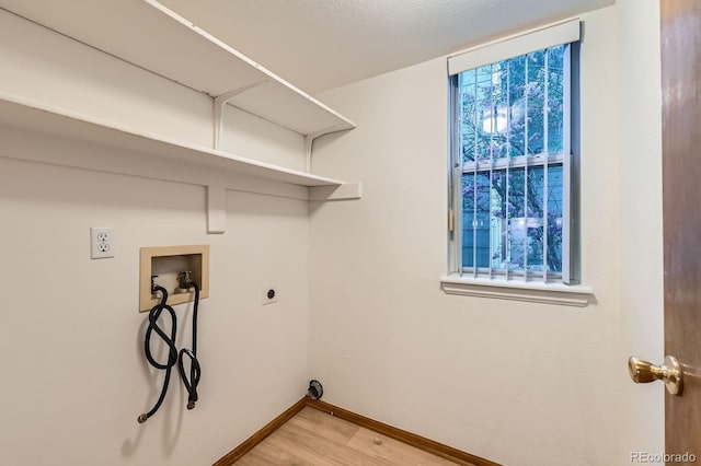 laundry room featuring laundry area, baseboards, electric dryer hookup, light wood-style flooring, and washer hookup