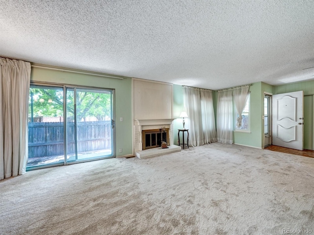 8730 E Roundtree Ave, Greenwood Village, CO 80111 - unfurnished living room featuring a textured ceiling, carpet floors, and a glass covered fireplace