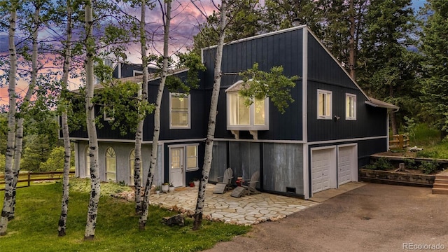 view of side of home featuring an attached garage, driveway, and fence