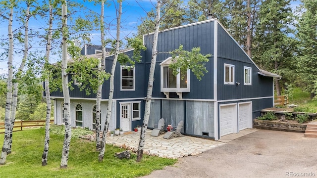 view of front facade featuring a garage, fence, aphalt driveway, and a front yard