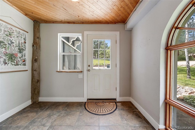 doorway to outside with wood ceiling, baseboards, and a wealth of natural light