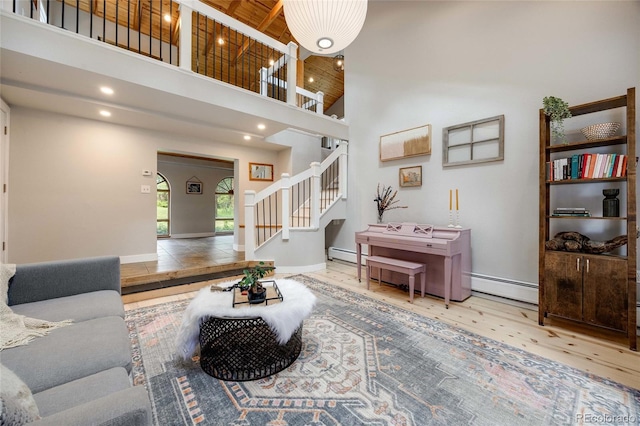 living room featuring baseboards, a towering ceiling, wooden ceiling, wood finished floors, and stairs