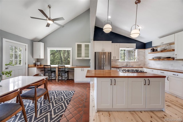 kitchen with wood counters, appliances with stainless steel finishes, white cabinets, and a sink