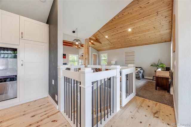 kitchen with open floor plan, double wall oven, light wood-style floors, white cabinetry, and pendant lighting