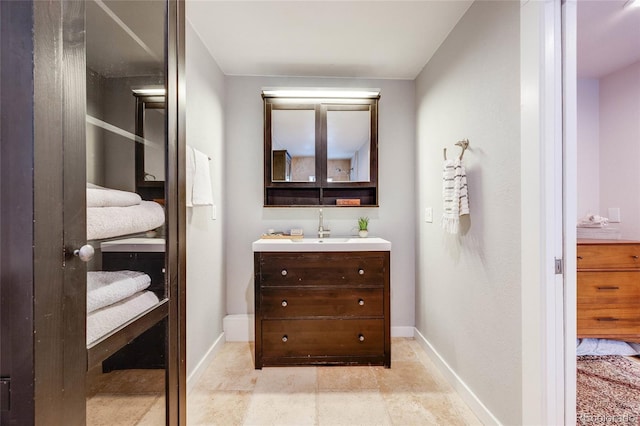 ensuite bathroom featuring vanity, baseboards, and ensuite bathroom