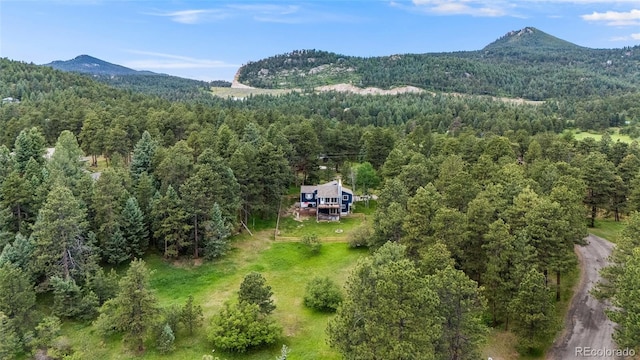 drone / aerial view featuring a mountain view and a view of trees