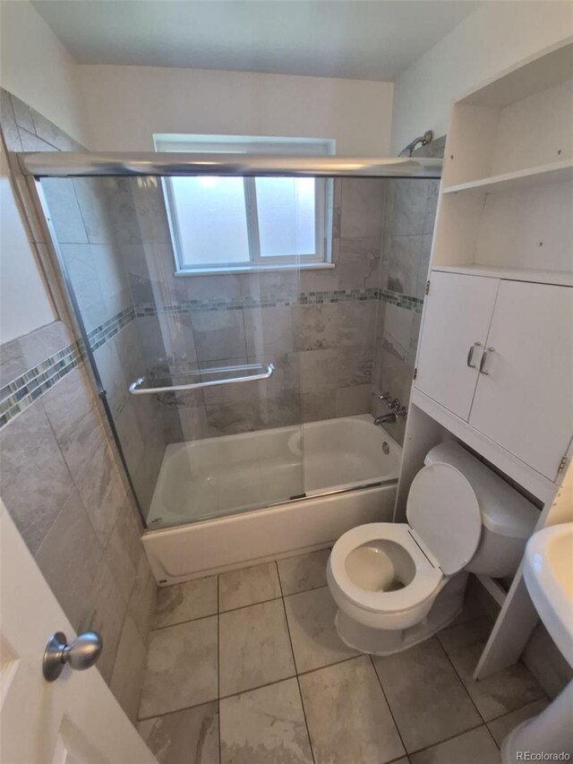 588 Empire St, Aurora, CO 80010 - full bath featuring toilet, combined bath / shower with glass door, and tile patterned flooring