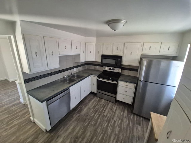 588 Empire St, Aurora, CO 80010 - kitchen featuring stainless steel appliances, a sink, dark countertops, white cabinetry, and decorative backsplash